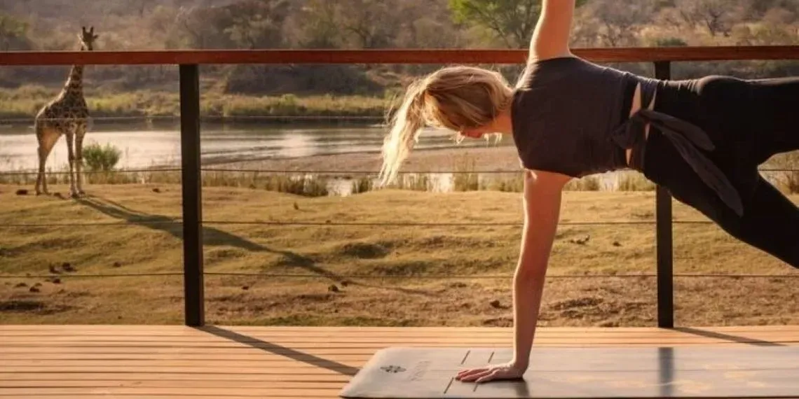 vrouw doet yoga met giraf op de achtergrond