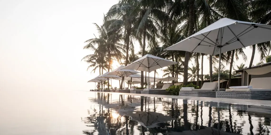 zwembad met parasol en loungers met palmbomen