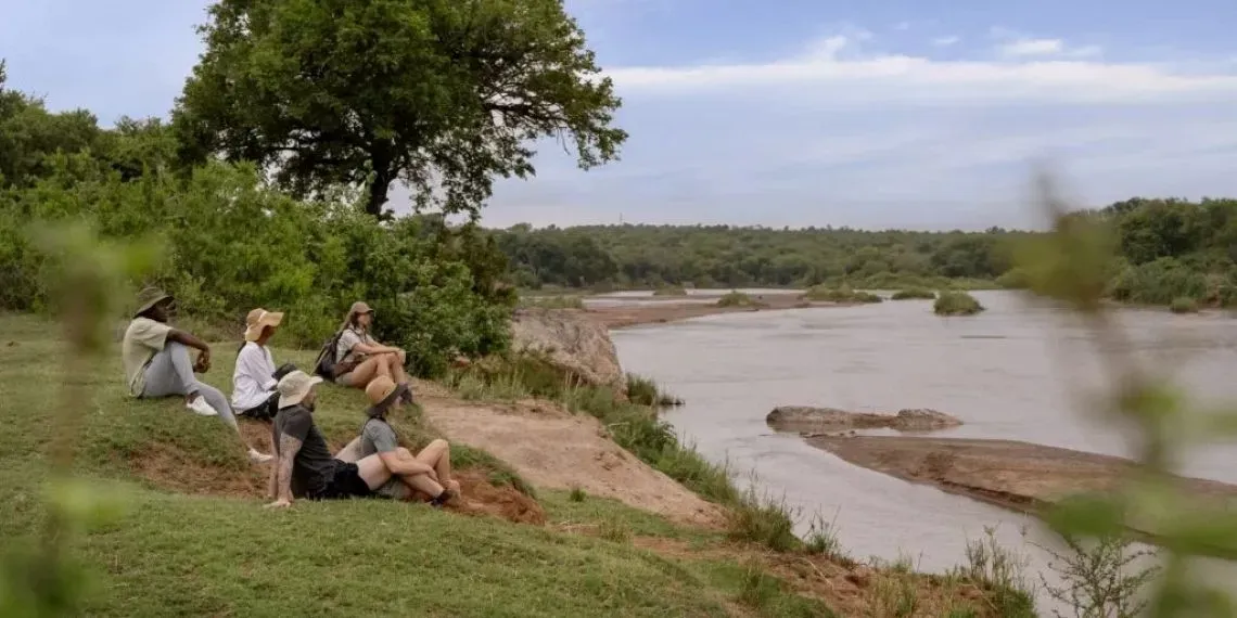 mensen zitten aan de kant van de rivier