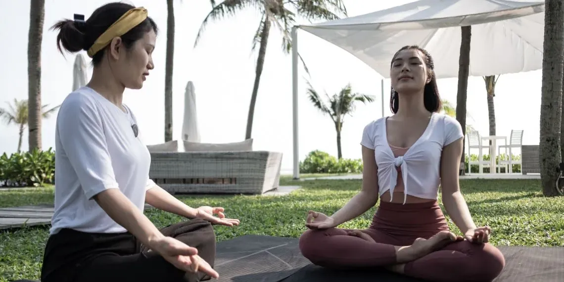 twee vrouwen mediterend in tuin